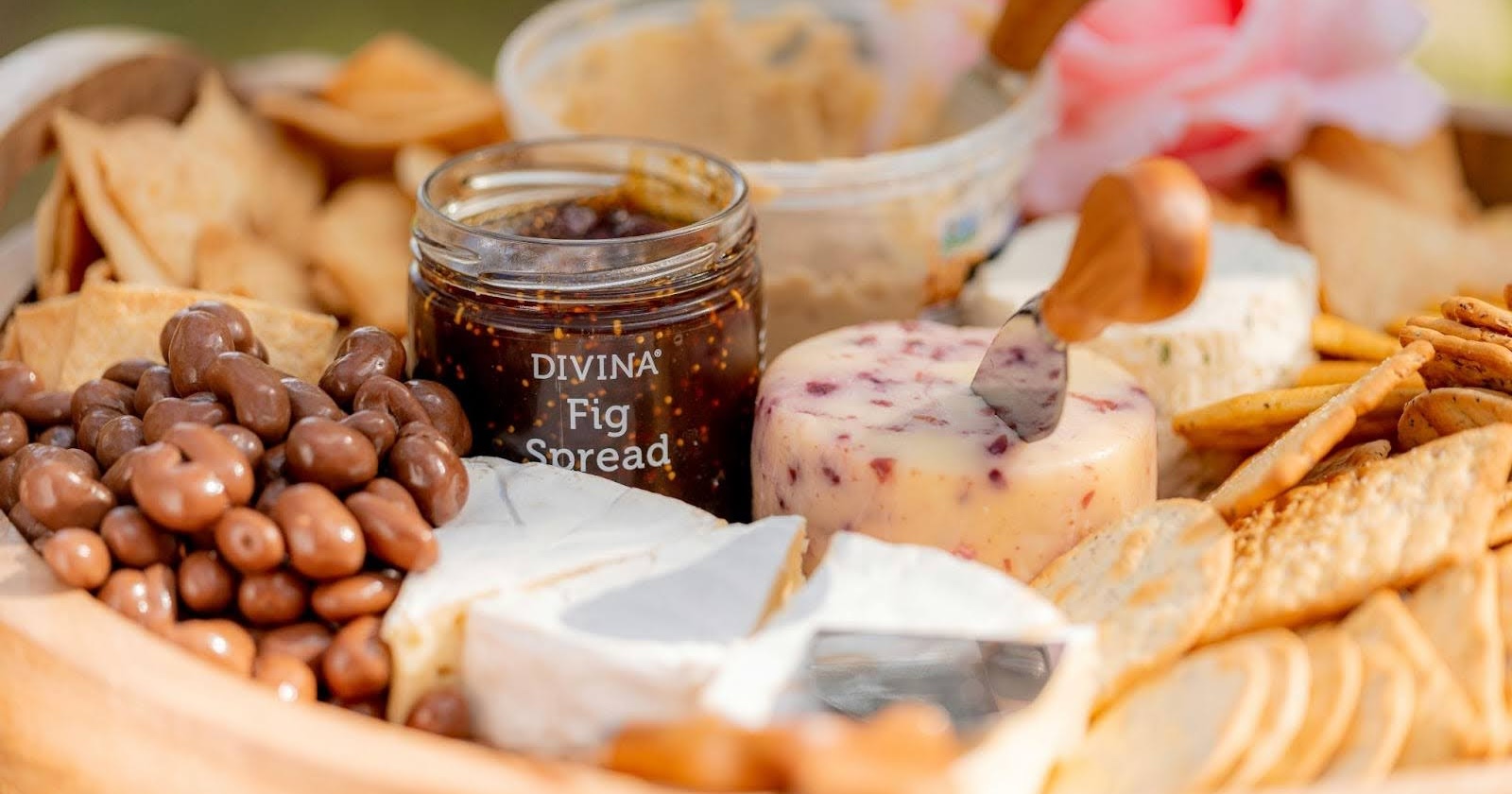 Artisan cheese board with fig spread, olives, crackers, and assorted cheeses arranged for gourmet entertaining
