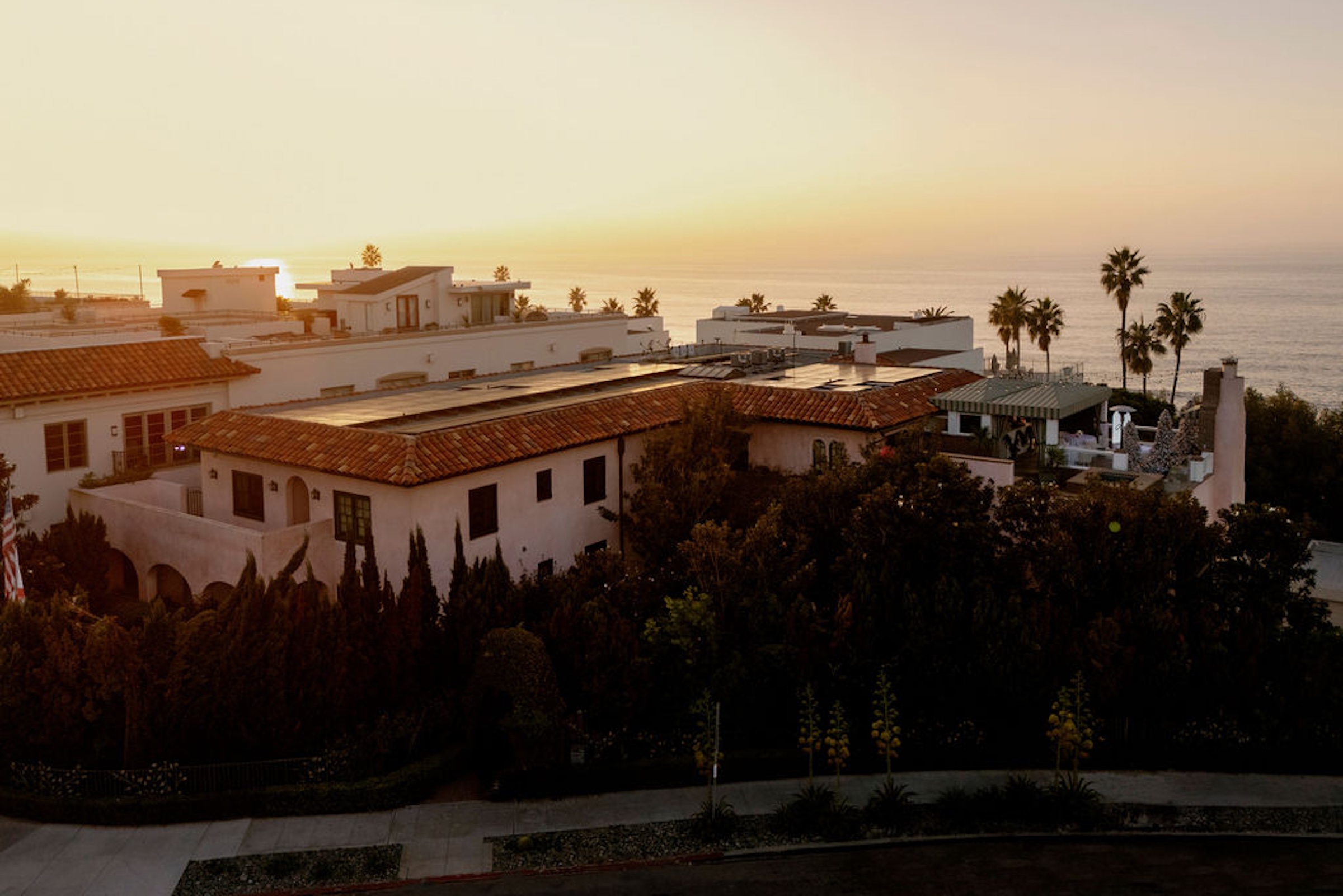 Golden hour settles over the coastline, casting a calm, timeless glow across the property and the sea beyond.