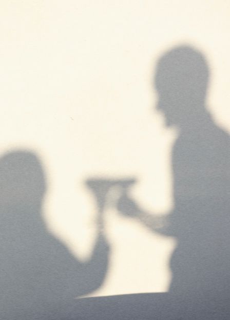 shadow of two people toasting