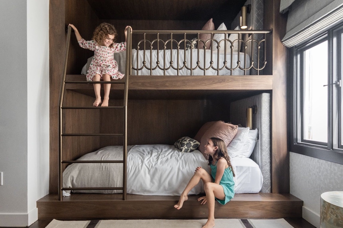 Two young girls playing on a bunk bed